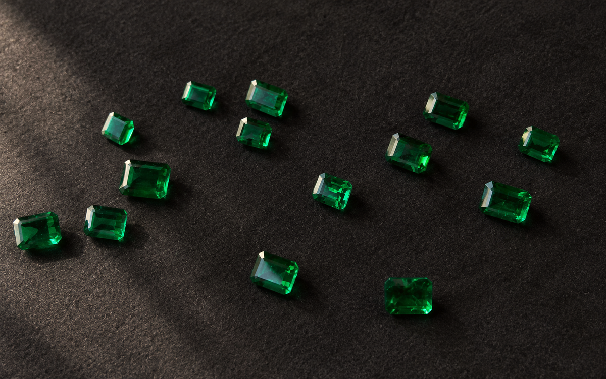 Loose emerald-cut gemstones on dark cloth